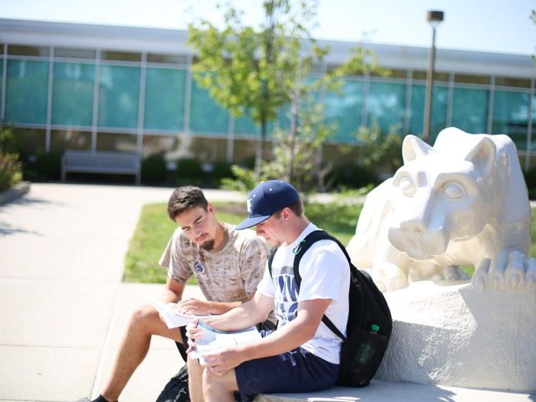 两个学生坐在狮子龛前读书